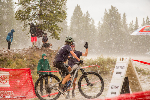 Riders give high five in a snowstorm in Leadville, Colorado
