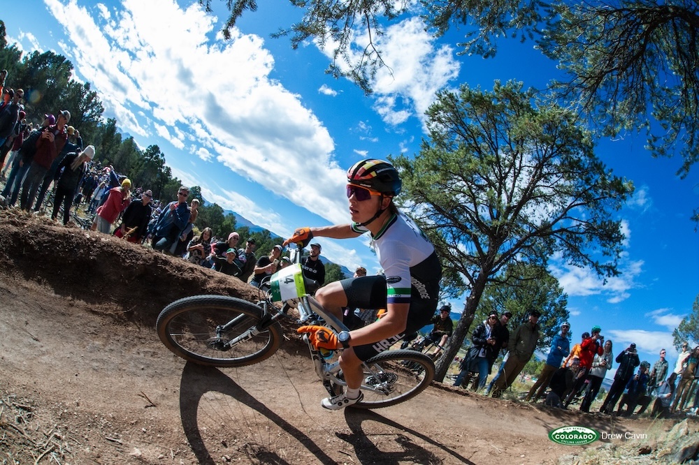 Rider Rounds A Bend With A Large Crowd On The Sidelines